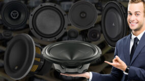 A man showing off a number of speakers